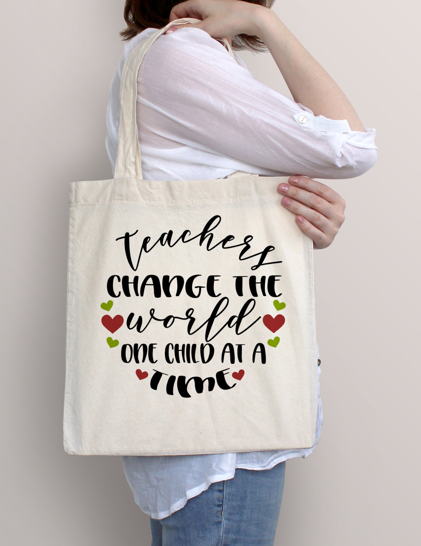 Woman carrying Teachers Change the World One Child at a Time cotton tote bag